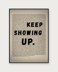 Keep Showing Up poster in black wood frame
